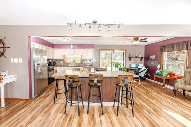 kitchen with white cabinetry, decorative backsplash, light wood-type flooring, and stainless steel fridge with ice dispenser