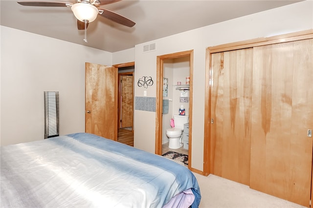 carpeted bedroom with ensuite bathroom and ceiling fan