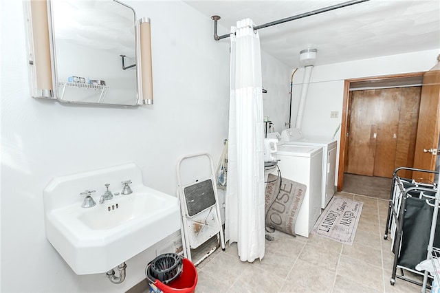 washroom with sink, washer and dryer, and light tile patterned floors