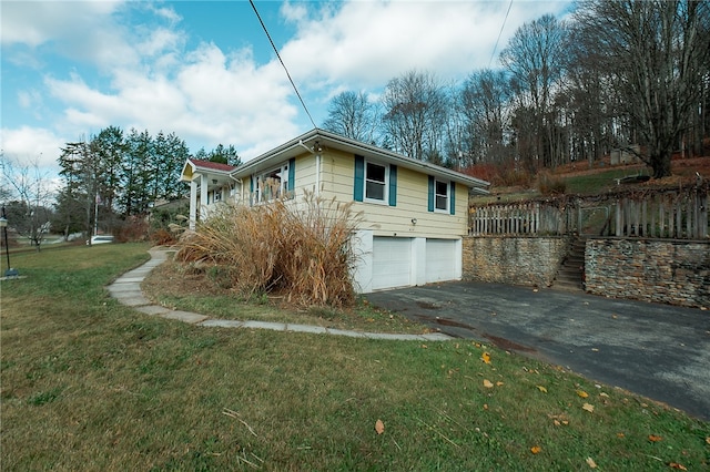 view of side of property featuring a garage and a lawn