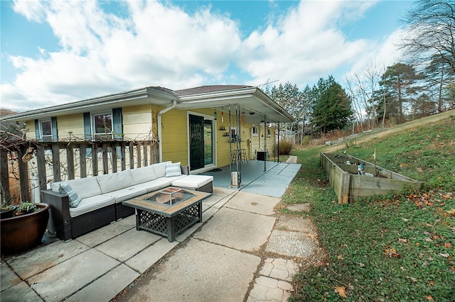 view of patio with an outdoor living space with a fire pit