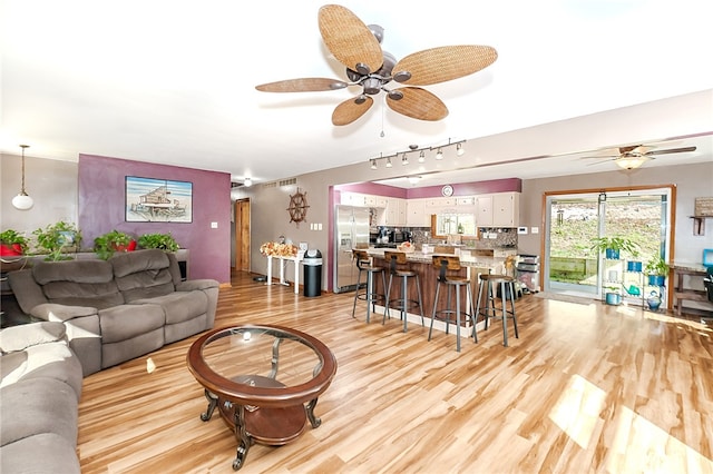 living room featuring ceiling fan and light hardwood / wood-style floors