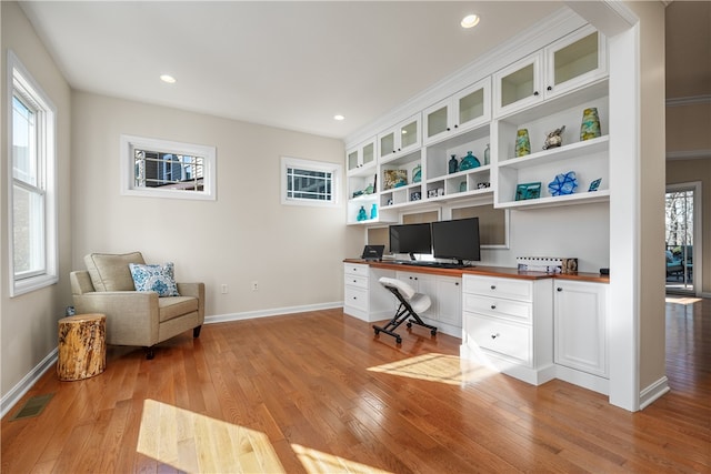 office featuring light hardwood / wood-style floors and built in desk