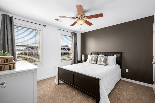 carpeted bedroom with ceiling fan and multiple windows