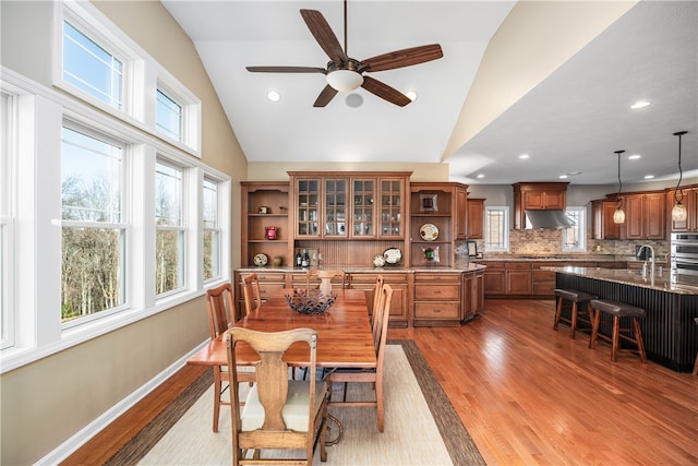 dining space with ceiling fan, wood-type flooring, and lofted ceiling