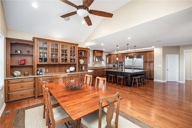 dining room with dark wood-type flooring, lofted ceiling, and ceiling fan