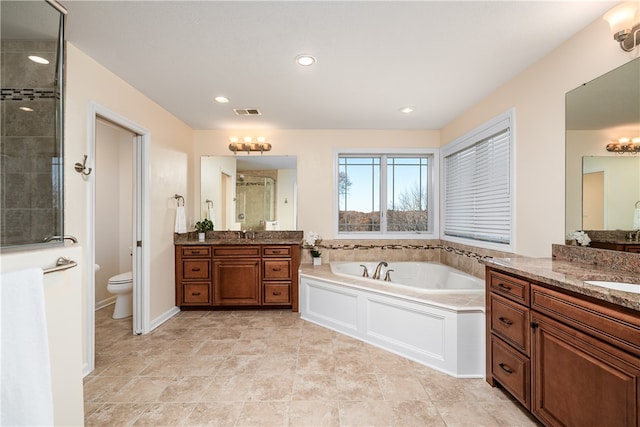 full bathroom featuring vanity, shower with separate bathtub, and toilet