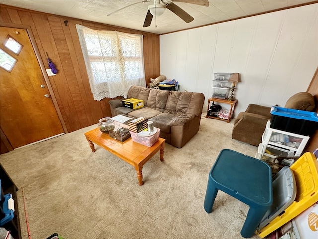 living room with wooden walls, ceiling fan, and carpet floors