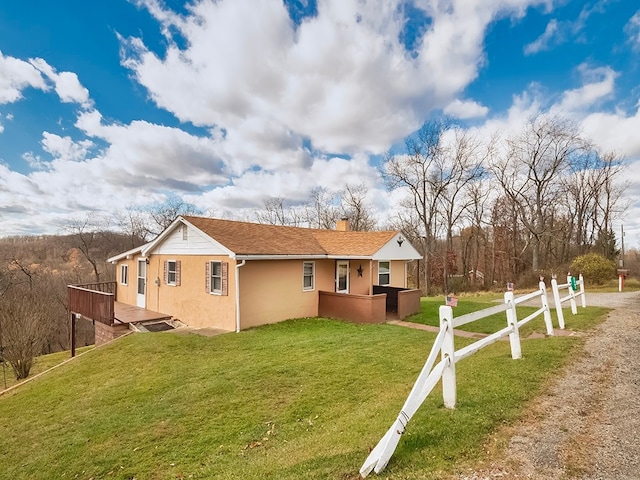 view of side of property featuring a wooden deck and a yard