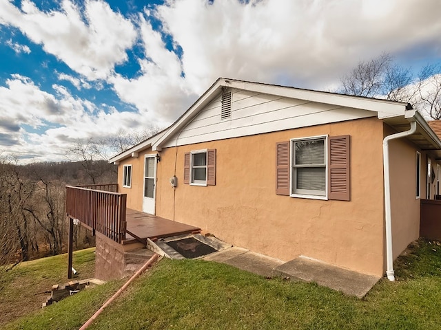 view of home's exterior with a lawn and a deck