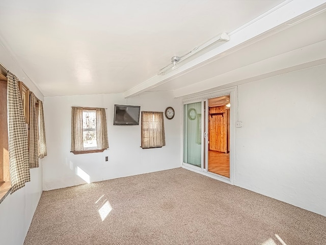 unfurnished room with carpet flooring and vaulted ceiling