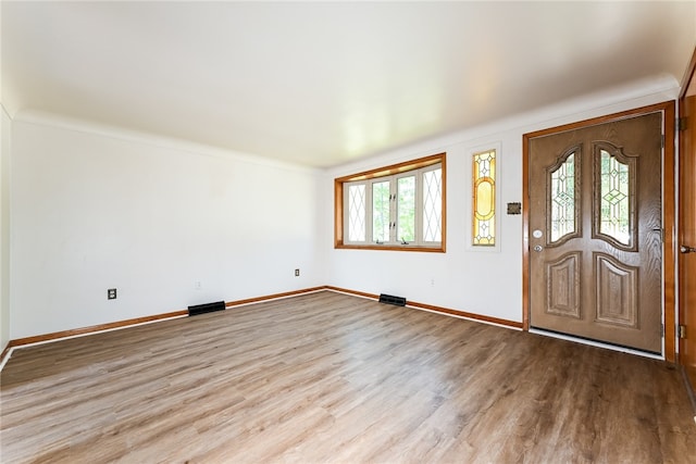 entryway with crown molding, light hardwood / wood-style floors, and plenty of natural light