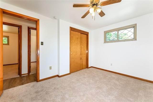 unfurnished bedroom featuring light carpet, ceiling fan, and a closet