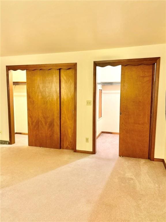 unfurnished bedroom with light carpet and a closet