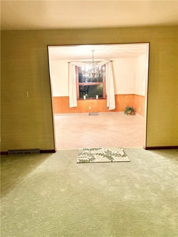 unfurnished room featuring wood walls and a chandelier