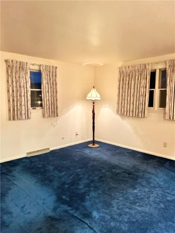 unfurnished room with dark colored carpet