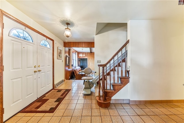 tiled foyer with a notable chandelier