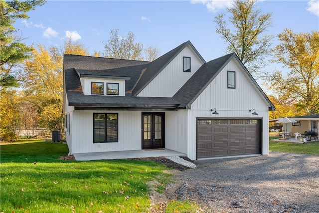 modern farmhouse style home featuring central AC, a front lawn, a garage, and french doors