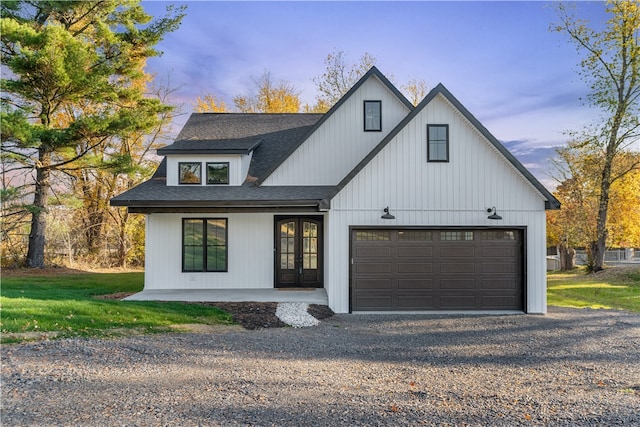 modern inspired farmhouse with a garage and a yard