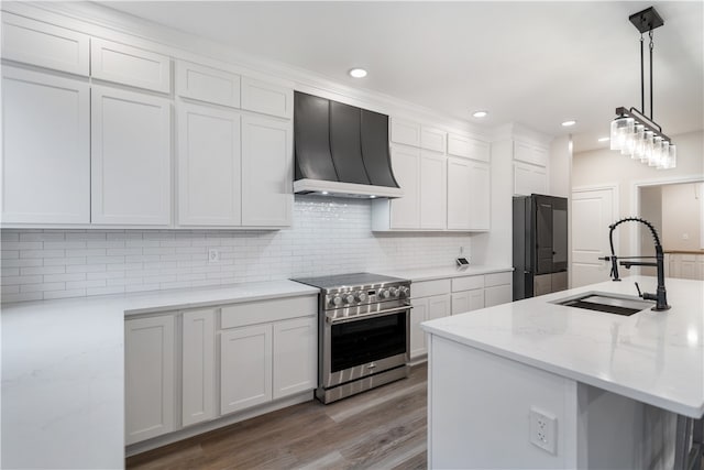 kitchen with premium range hood, appliances with stainless steel finishes, decorative light fixtures, sink, and white cabinets