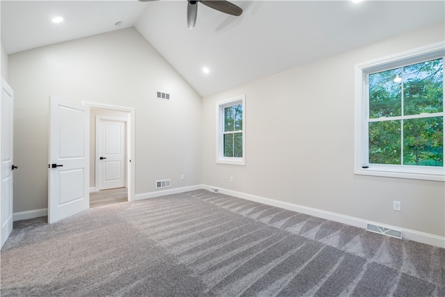 carpeted spare room featuring high vaulted ceiling and ceiling fan