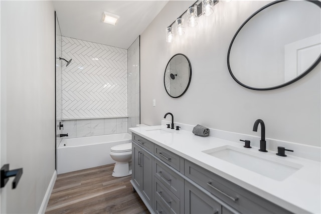 full bathroom with tiled shower / bath, hardwood / wood-style flooring, toilet, and vanity