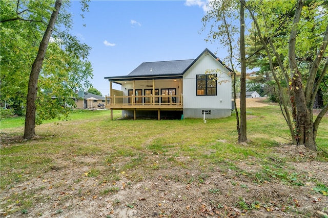 rear view of property featuring a deck, ceiling fan, and a yard