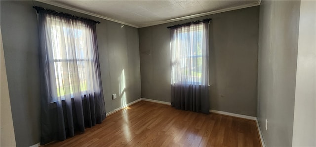 unfurnished room featuring hardwood / wood-style flooring, a healthy amount of sunlight, and crown molding