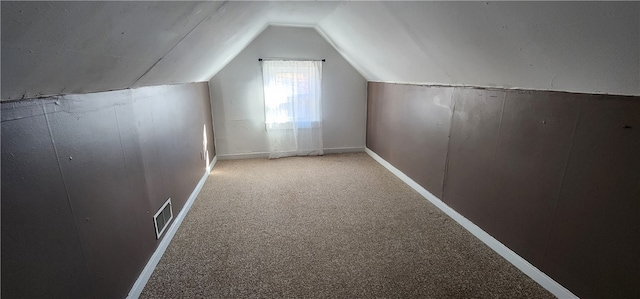 additional living space with vaulted ceiling and carpet floors