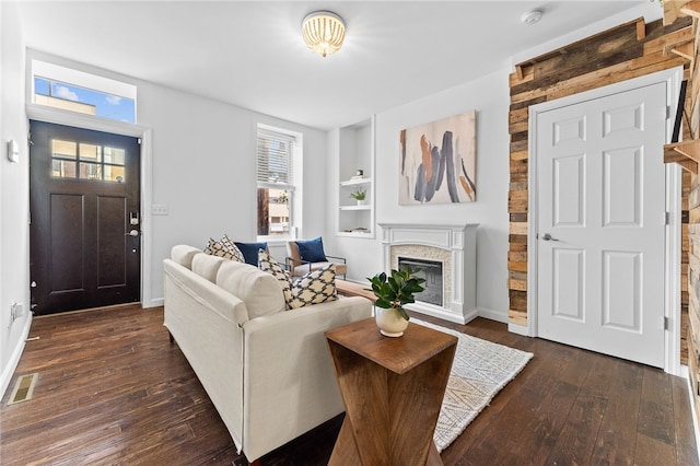 living room with dark wood-type flooring and built in shelves