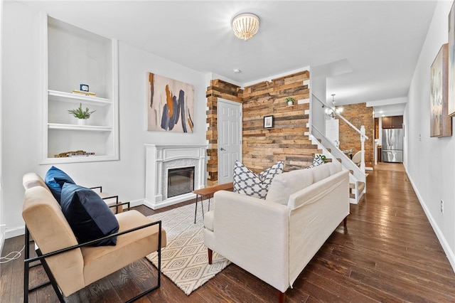 living room featuring wooden walls, dark hardwood / wood-style floors, and a notable chandelier