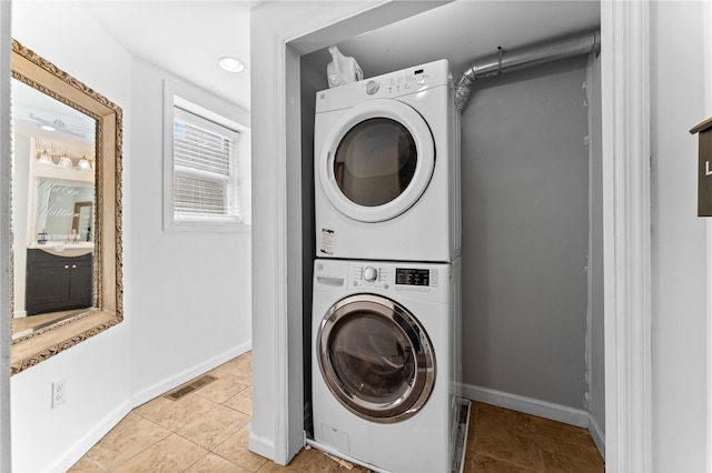 washroom featuring light tile patterned flooring and stacked washer / drying machine