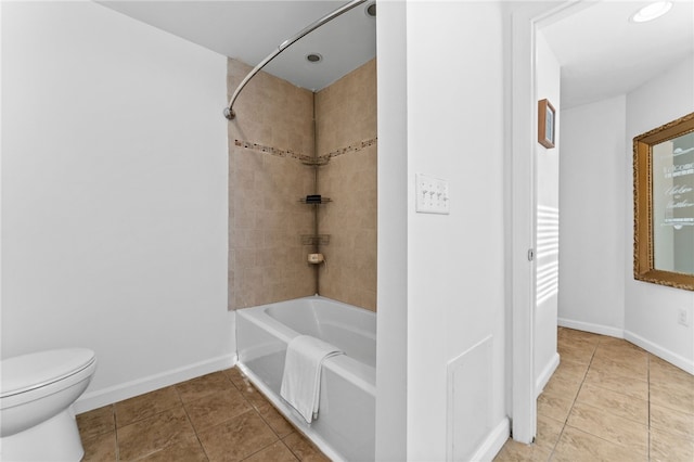 bathroom featuring toilet, tiled shower / bath, and tile patterned floors