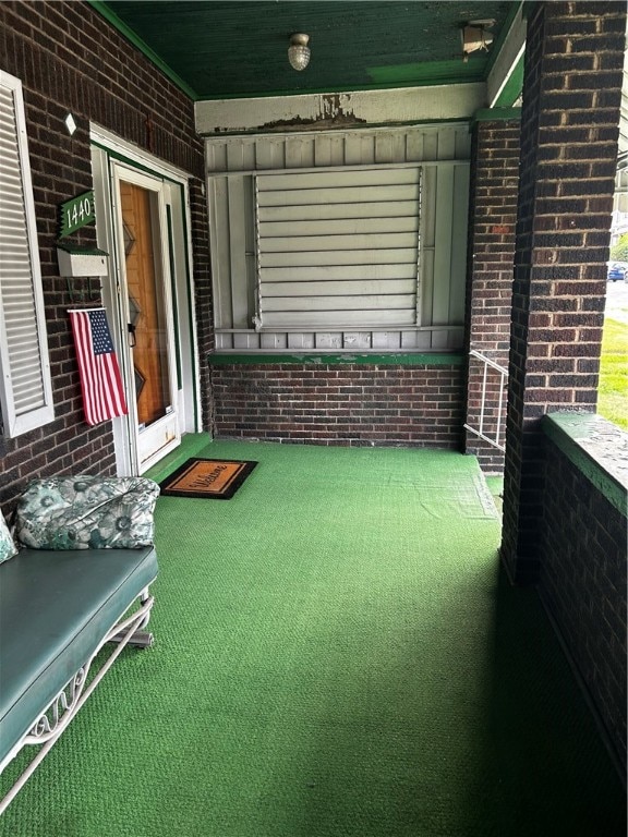 game room with carpet flooring and brick wall