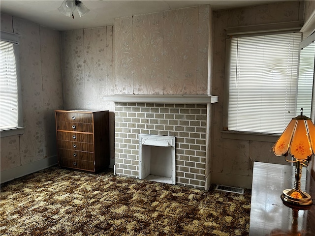 unfurnished living room with ceiling fan and carpet floors