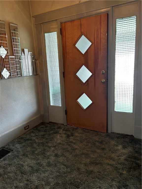 entrance foyer featuring dark carpet