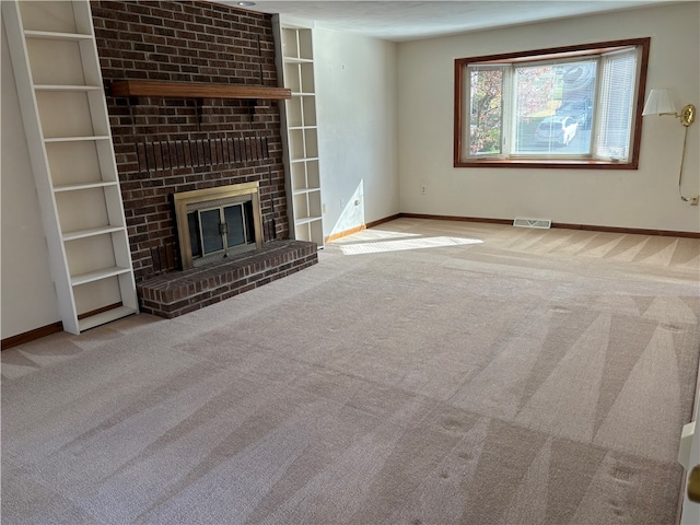 unfurnished living room featuring a brick fireplace and light colored carpet