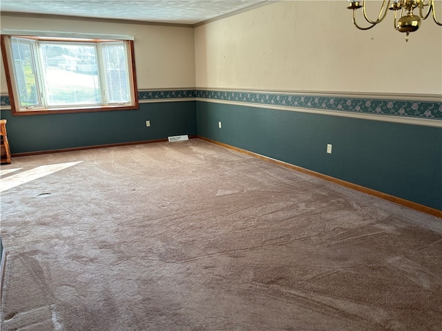 empty room featuring a textured ceiling, light carpet, and ornamental molding