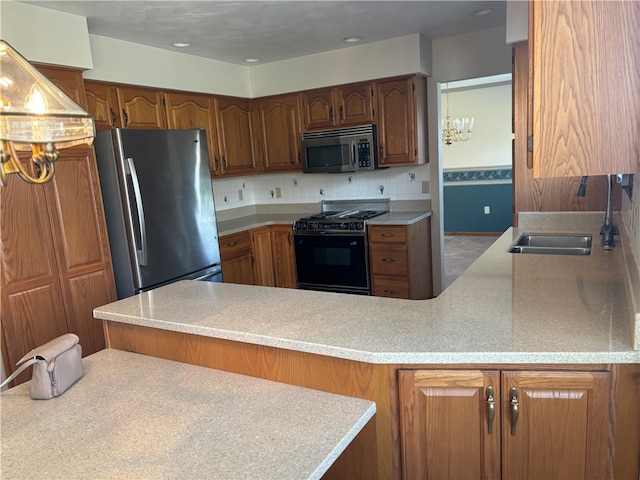 kitchen with sink, kitchen peninsula, appliances with stainless steel finishes, tasteful backsplash, and a chandelier