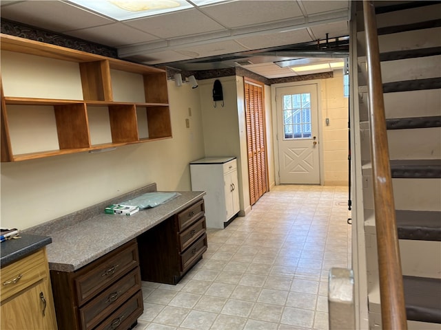 interior space with dark brown cabinets and a drop ceiling