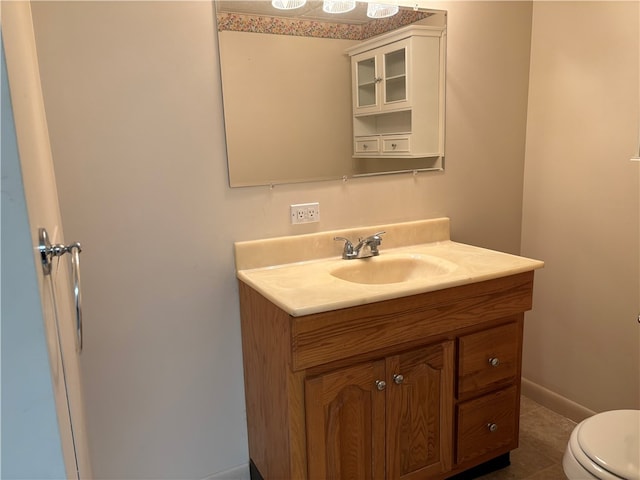 bathroom with toilet, vanity, and tile patterned flooring