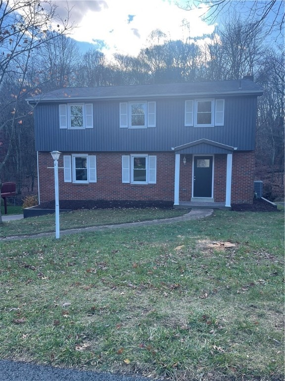 front facade featuring central AC unit and a front yard