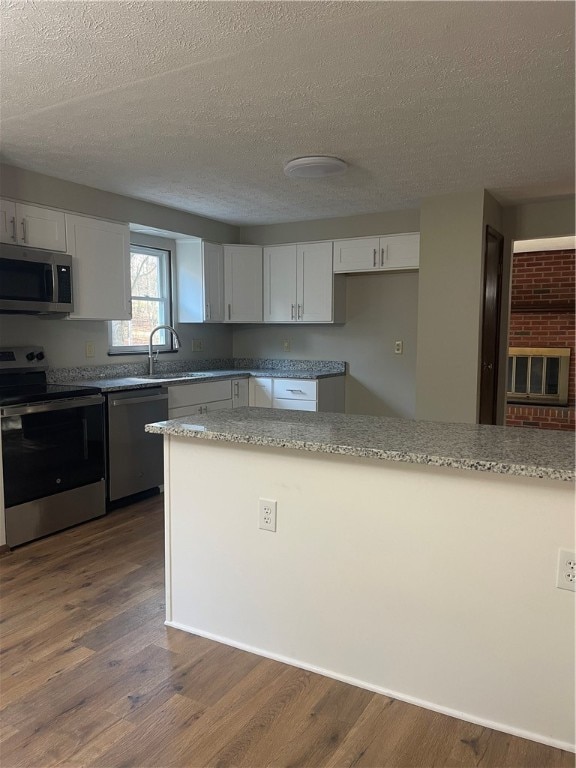 kitchen featuring appliances with stainless steel finishes, dark hardwood / wood-style floors, and white cabinets