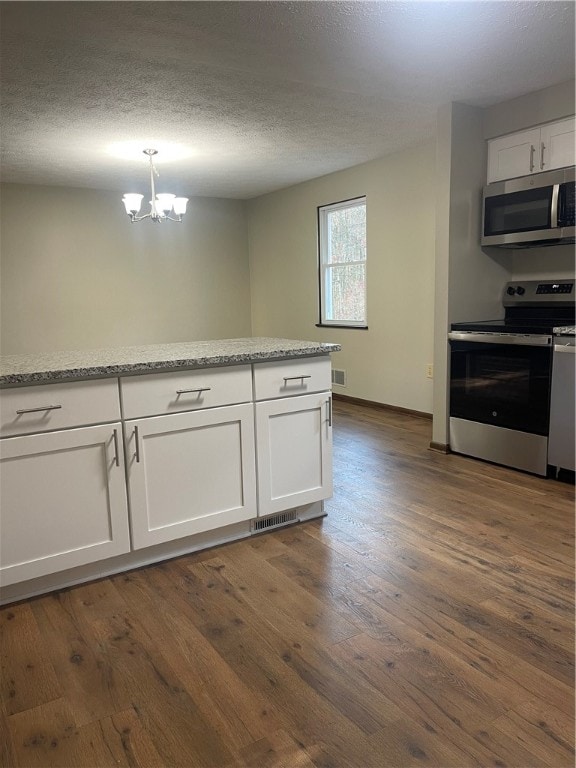 kitchen with white cabinetry, stainless steel appliances, dark wood-type flooring, and hanging light fixtures