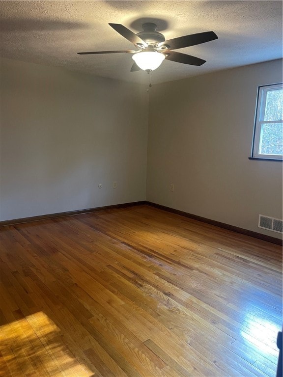 unfurnished room with light hardwood / wood-style floors, ceiling fan, and a textured ceiling