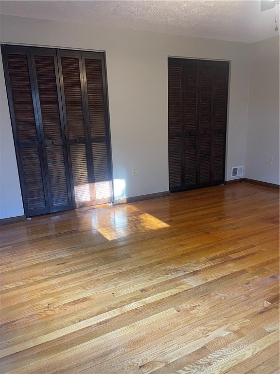 unfurnished bedroom with light hardwood / wood-style floors and a textured ceiling