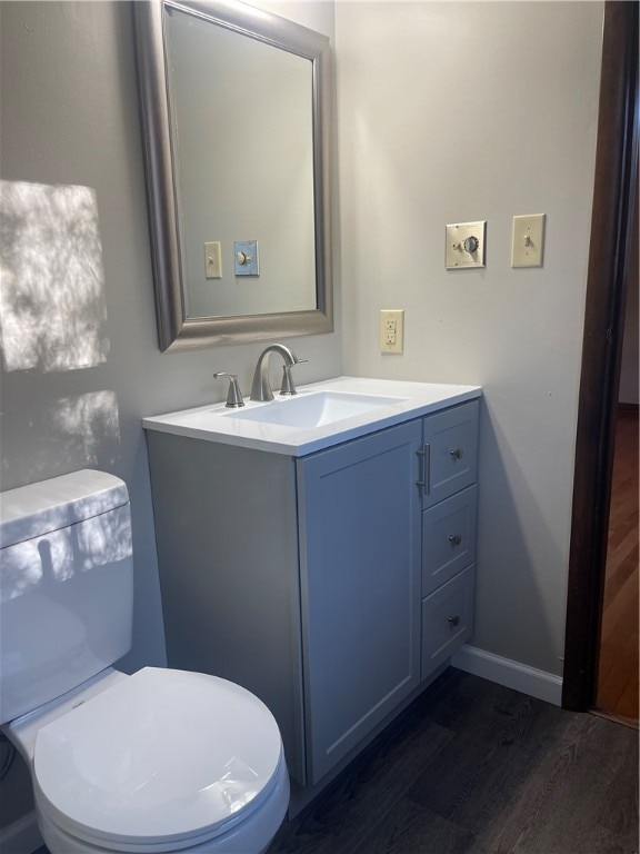 bathroom with vanity, hardwood / wood-style flooring, and toilet