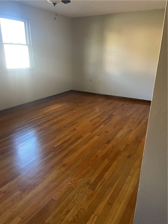 spare room with dark wood-type flooring and ceiling fan