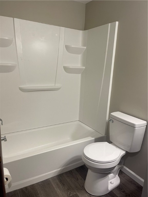 bathroom featuring hardwood / wood-style flooring, tub / shower combination, and toilet