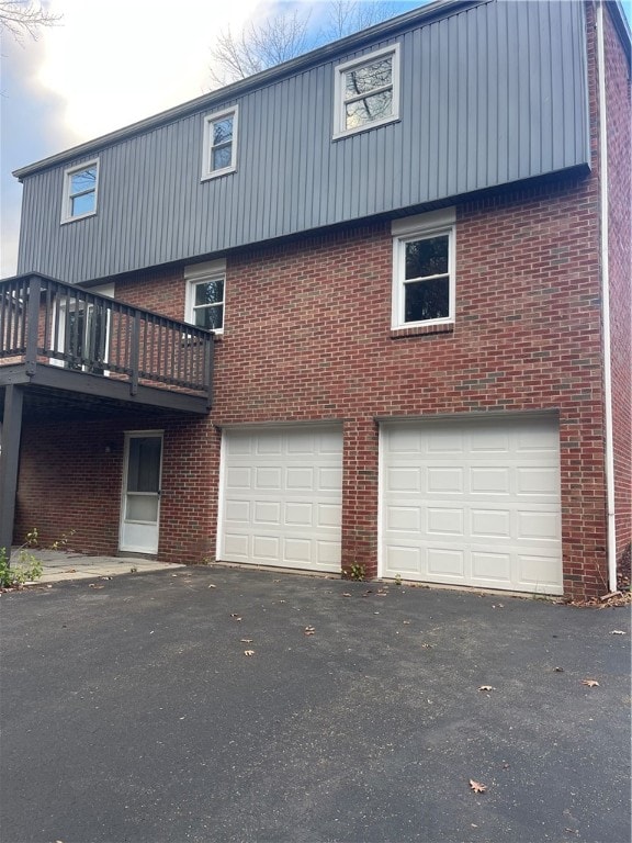 back of house with a garage and a deck